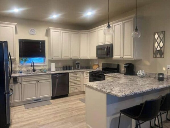 Enjoy cooking in this well-equipped kitchen with a central island, appliances, and ample counter space.