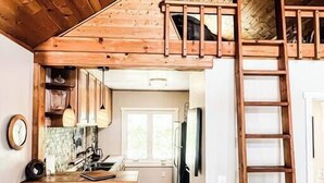 A loft-style kitchen with a wooden ceiling, a central island, and a built-in ladder. - The Nest: Serene Sanctuary w Hot Tub, Fireplace, Grill, Hammock, Outdoor Fire Fe (Idyllwild-Pine Cove)