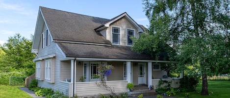 Une maison à deux étages avec un porche à l’avant, un hall d’entrée abrité et une pelouse bien entretenue.