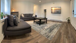 Una sala moderna con un sofá gris, una mesa de centro y un tapete grande.