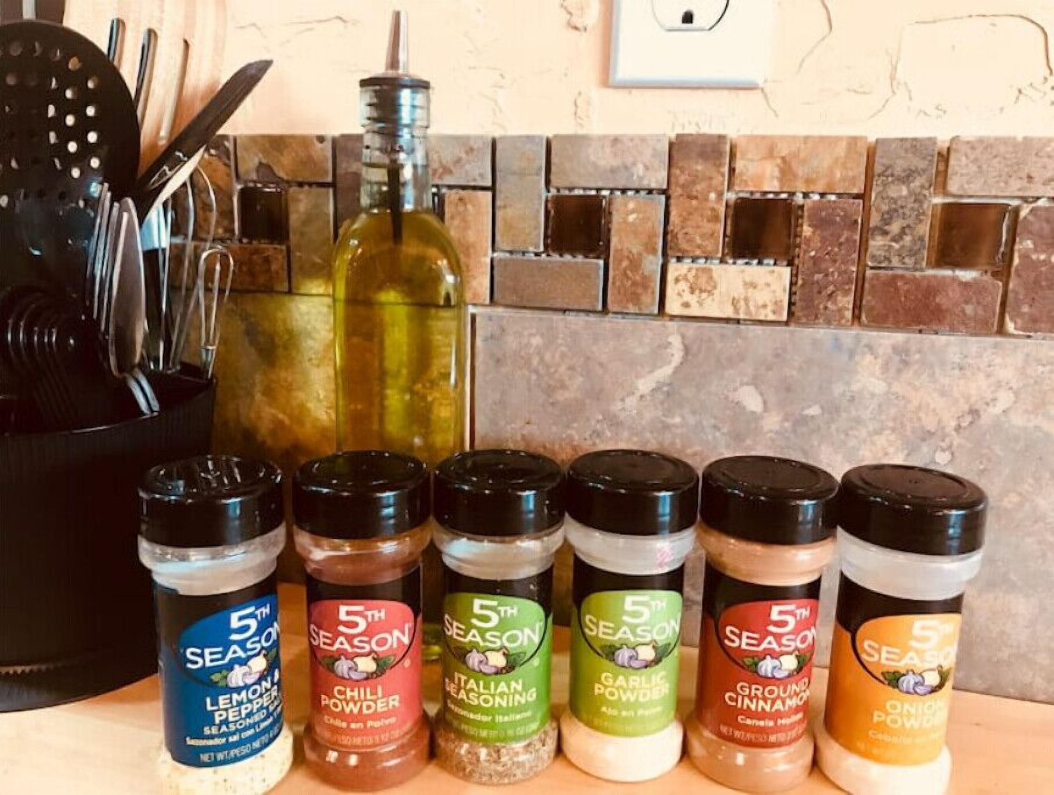 A kitchen counter with various seasonings and a bottle of olive oil.