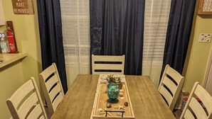 A dining area with a wooden table, four chairs, a decorative tray, and a ceiling fan. - COASTAL CORAL -A few steps to the Beach, Pier, Park & close to all Boat Ramps.  (Port O'Connor)