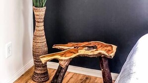 A corner with a tall, woven plant pot and a rustic wooden table.