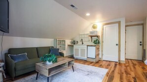 A compact living space with a sofa, coffee table, and a small kitchen area. - Cozy Sanctuary/Dwtn Franklin Studio w Priv Entry (Franklin)