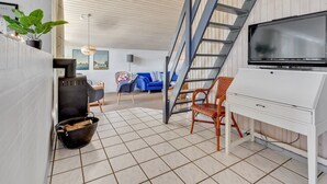 Uma sala de estar moderna com lareira, televisão e escada.