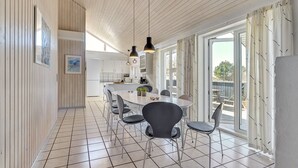 Cozinha moderna com bancada comprida, luminárias pendentes e vista para o exterior.
