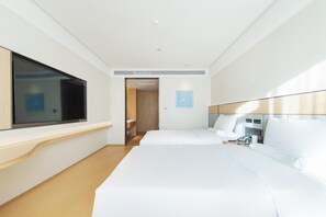 A hotel room with two beds, a TV, a bedside table, and a bathroom visible through an open door. - Ji Hotel Shenyang Yuhong Xincheng (Shenyang)