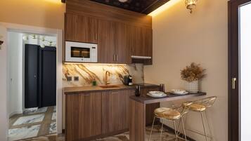 Uma cozinha moderna com armários de madeira, bancada de mármore e um espaço de bar com banquetas.