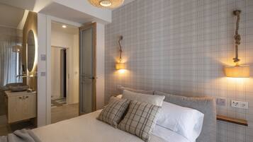 A modern bedroom with a large bed, bedside lamps, a mirror, and a wooden nightstand.