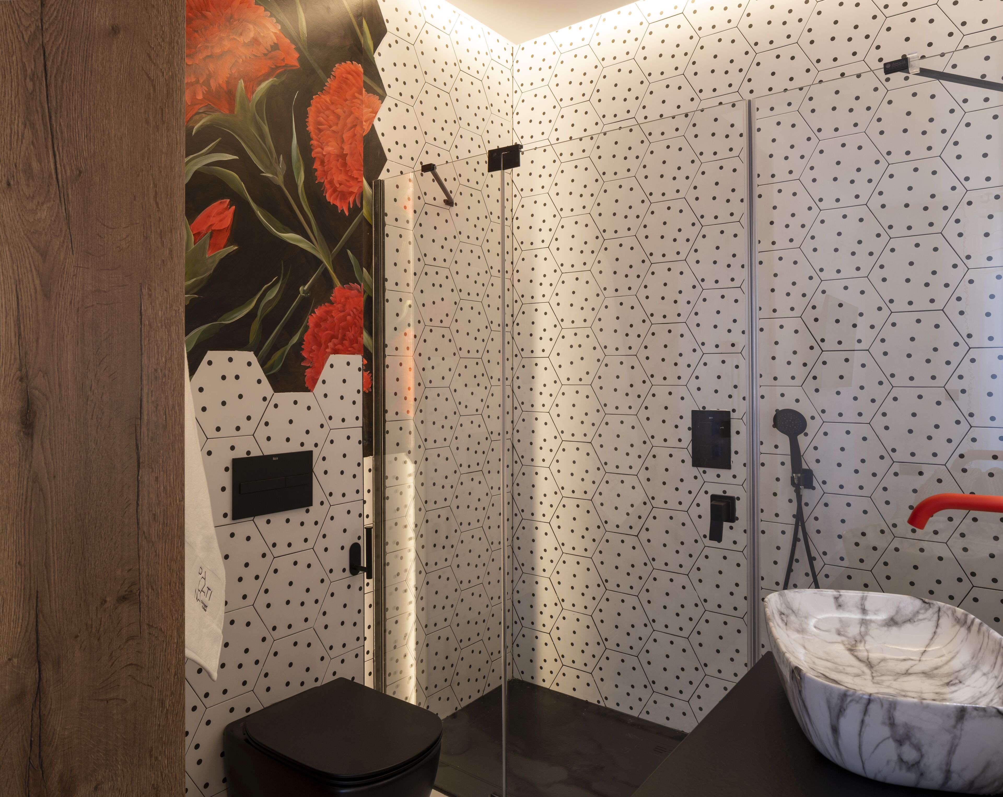 Een moderne badkamer met douche, toilet en wastafel.
