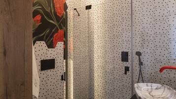 Een moderne badkamer met douche, toilet en wastafel.