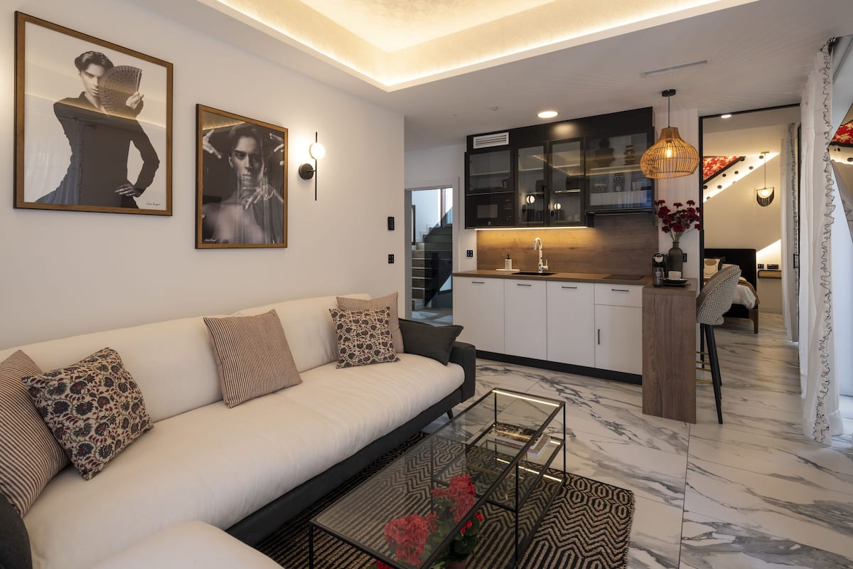A modern living room with a sofa, coffee table, and artwork on the wall.