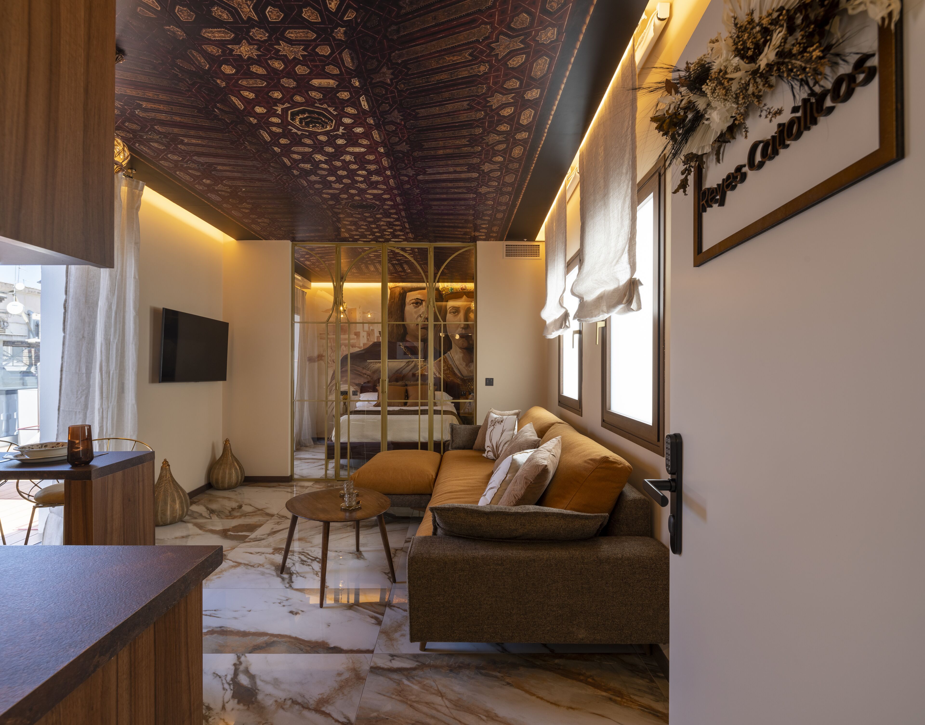 A modern living room with a sofa, a coffee table, and a TV mounted on the wall.