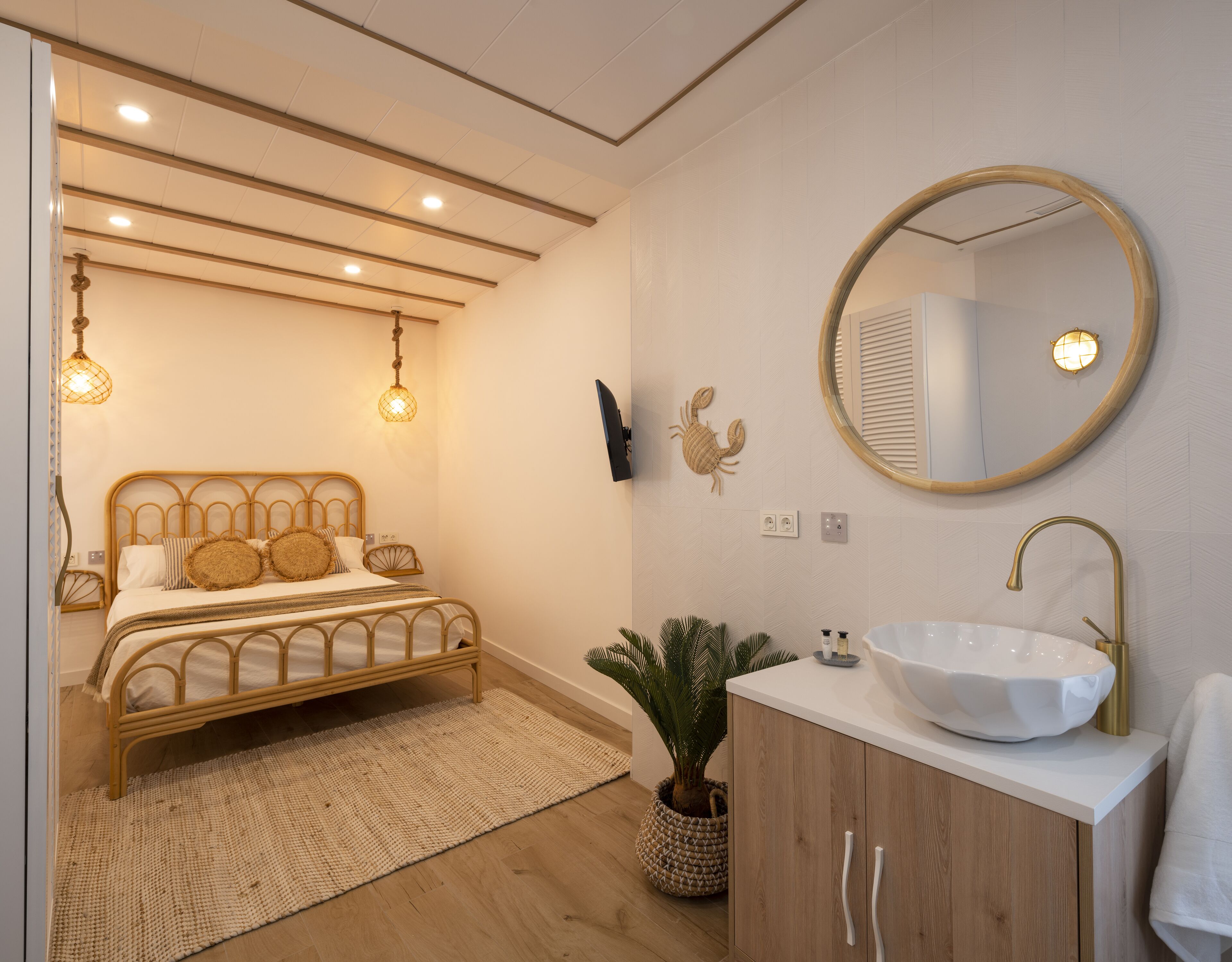 A bedroom with a bed, bedside lamp, and a wall-mounted TV.