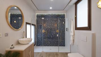 Une salle de bain moderne avec une baignoire sur pieds, un miroir rond et des toilettes.