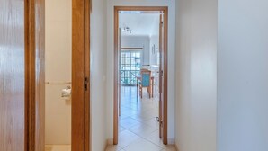 Un corridoio che porta a una sala da pranzo con vista su un balcone.