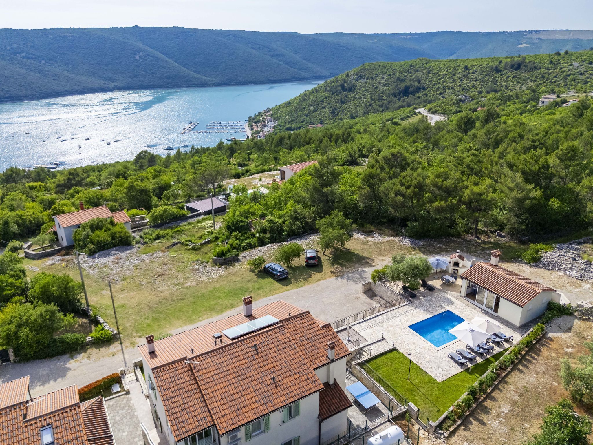 Zona residencial amb piscina, cases adossades i vistes a un llac.