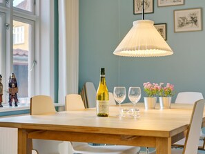 A dining table with a bottle of wine, glasses, and potted plants. - "Reko" - 500m from the sea by Interhome (Skagen)