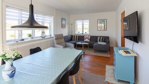A modern living room with a dining table, sofa, and TV. - "Borka" - 150m from the sea by Interhome (Skagen)