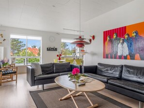 A modern living room with a sofa, coffee table, and artwork.
