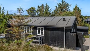 A small, dark wooden building with a metal roof, a window, and a door. - "Thorkil" - 800m from the sea by Interhome (Skagen)