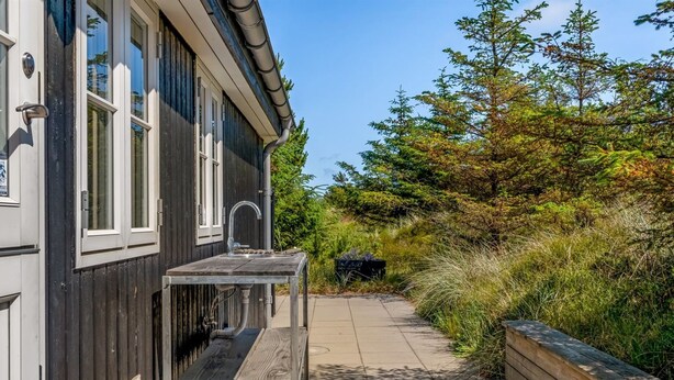 A wooden deck with a built-in bench, a small table, and a sink. - "Thorkil" - 800m from the sea by Interhome (Skagen)