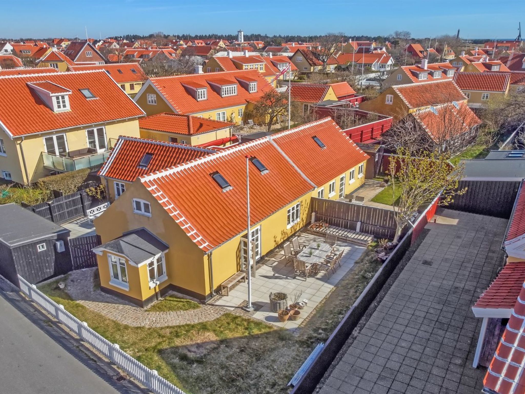 Un quartier résidentiel où les maisons se distinguent par leurs toits recouverts de tuiles rouges et par leurs façades aux couleurs variées, allant du jaune au gris.