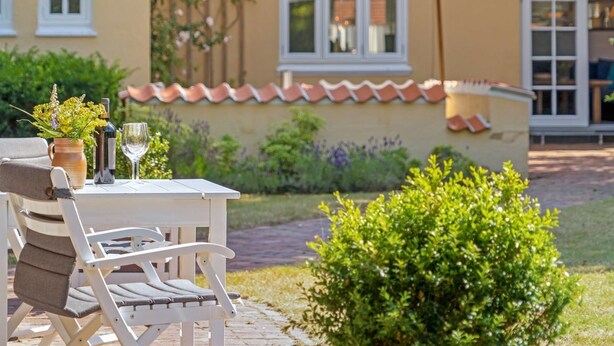 An outdoor seating area with a table, chairs, and a patio umbrella.