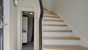 A staircase with wooden steps and a white wall.