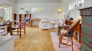 A cozy room with a wooden floor, white walls, a bunk bed, a desk, and a chair.