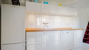 A kitchen with white cabinets, a wooden countertop, and a dishwasher.