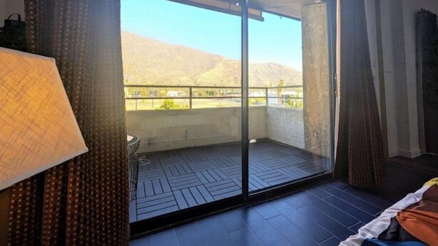 A room with a large sliding glass door leading to a balcony with a view of hills. - PalmSpringsBNB - Renovated 1Bd with Amazing Views (Palm Springs)