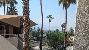 A modern building with a concrete facade and a palm tree in the foreground. - PalmSpringsBNB - Renovated 1Bd with Amazing Views (Palm Springs)
