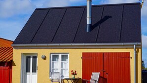 A yellow building with a black roof, a red door, and a chimney. - "Elle" - 50m from the sea by Interhome (Skagen)