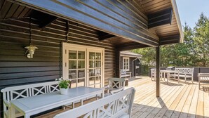 A wooden deck with white furniture, including a bench and a table, and a covered area with a grill. - "Dorthea" - 200m from the sea by Interhome (Jerup)