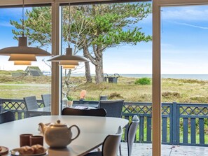 An outdoor dining area with a table, chairs, and a view of the beach and dunes. - "Djuna" - 200m from the sea by Interhome (Læsø)