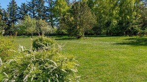 Un parc verdoyant avec des arbres et des arbustes.