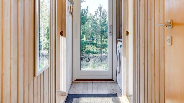A wooden interior hallway with a door leading to an outdoor area.