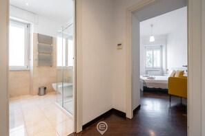 Un bagno moderno con cabina doccia in vetro, un water e un porta asciugamani.