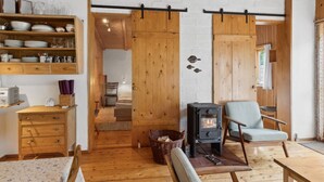 Una stanza accogliente con pavimento in legno, un letto, una sedia, un tavolo e un camino.