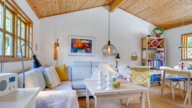 A cozy living room with a wooden ceiling, a sofa, a coffee table, and a bookshelf. - "Mirla" - 300m from the sea by Interhome (Læsø)