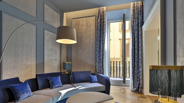 A modern living room with a sectional sofa, a round coffee table, and a floor lamp.