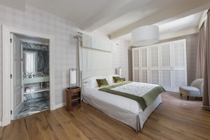 Une chambre à coucher avec un lit, une armoire, un miroir, une fenêtre et une porte.