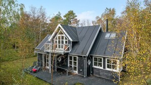 Une maison à deux étages avec un balcon, un garage et une cheminée.