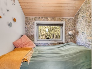 A bedroom with a window, a bed, a wall clock, and a patterned wallpaper. - "Tishon" - 100m from the sea by Interhome (Læsø)