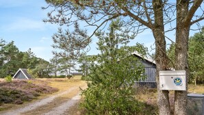 A rural setting with a gravel path, a wooden structure, and a utility box.