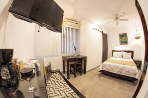 Relax in this stylish room with a flat-screen TV, ceiling fan, and comfortable bed.