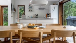 Una cucina moderna con mobili bianchi, un'isola grande e un lampadario a sospensione.