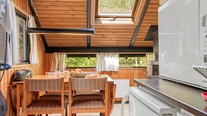 A cozy cabin with wooden walls and a dining area featuring a table and chairs.