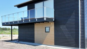 Un immeuble moderne à deux étages, doté d’un balcon au dernier étage.
